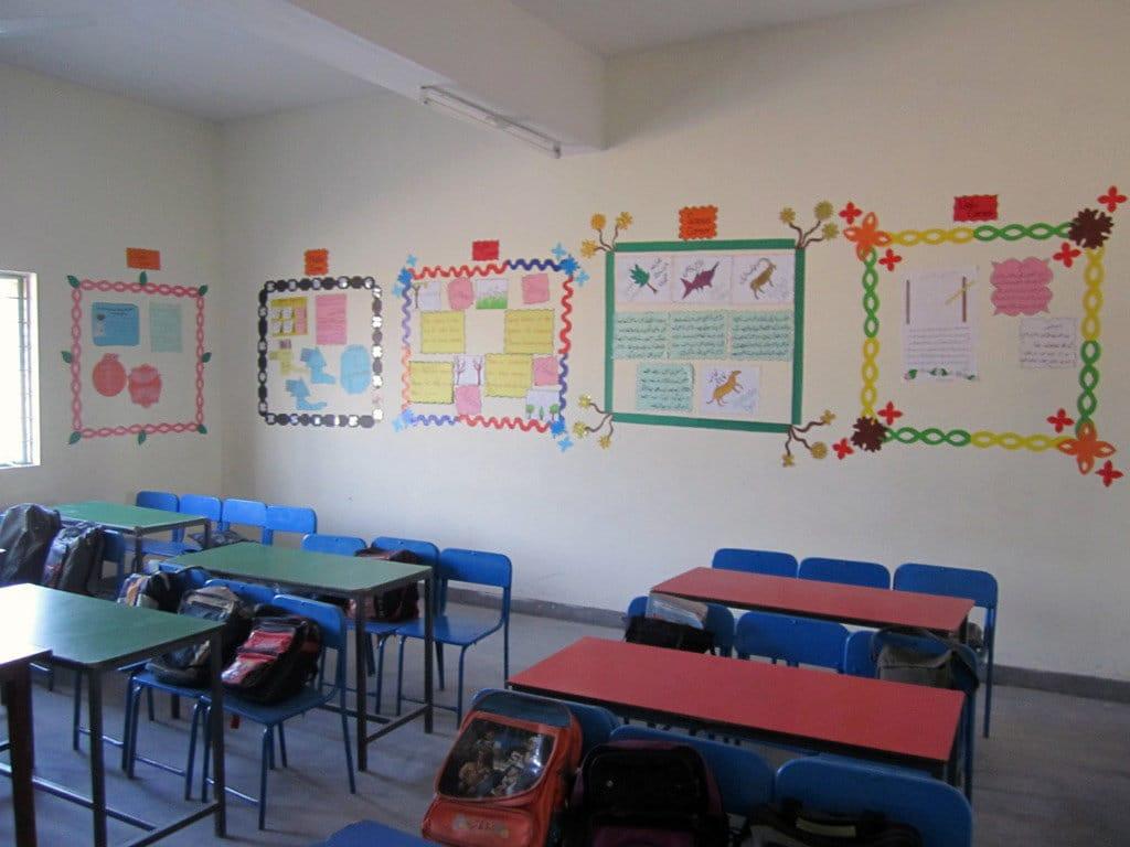 A modern, well-lit classroom with neat desks and a whiteboard.